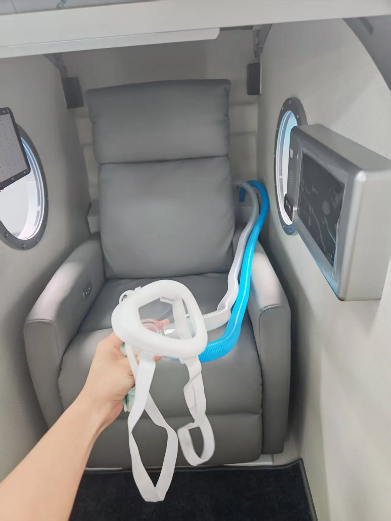 Interior real de la cámara Time Machine con asiento reclinable, mascarilla BIBS y mangueras de respiración