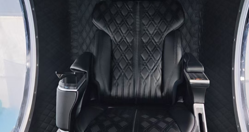 Primer plano de un asiento negro acolchado de la cámara Time Machine y sus controles en el apoyabrazos